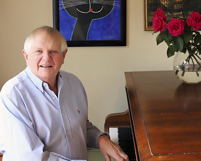 portrait of London-based composer Paul Williams at the Keyboard of his grand piano